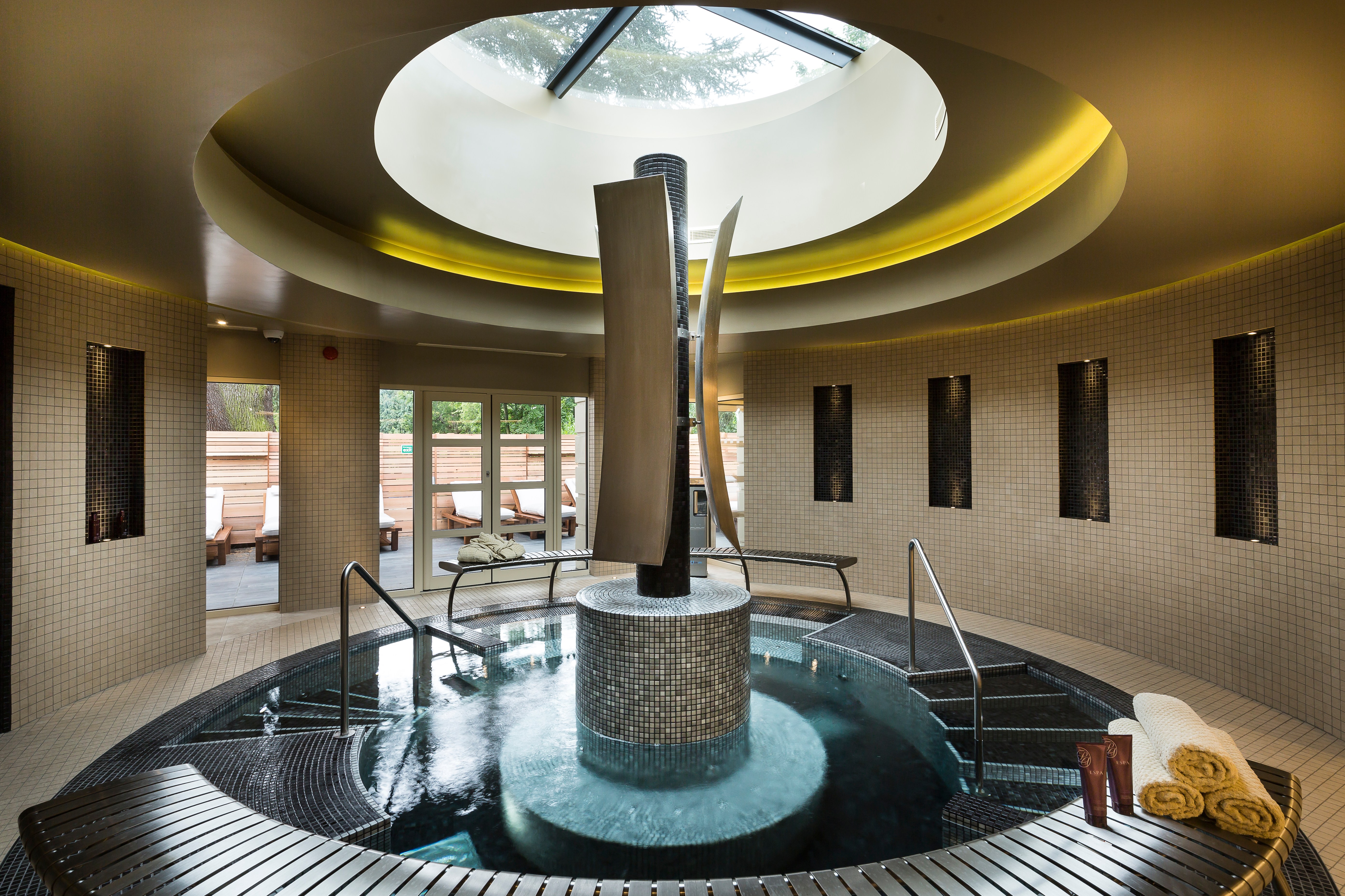 Indoor spa pool with a central water feature.