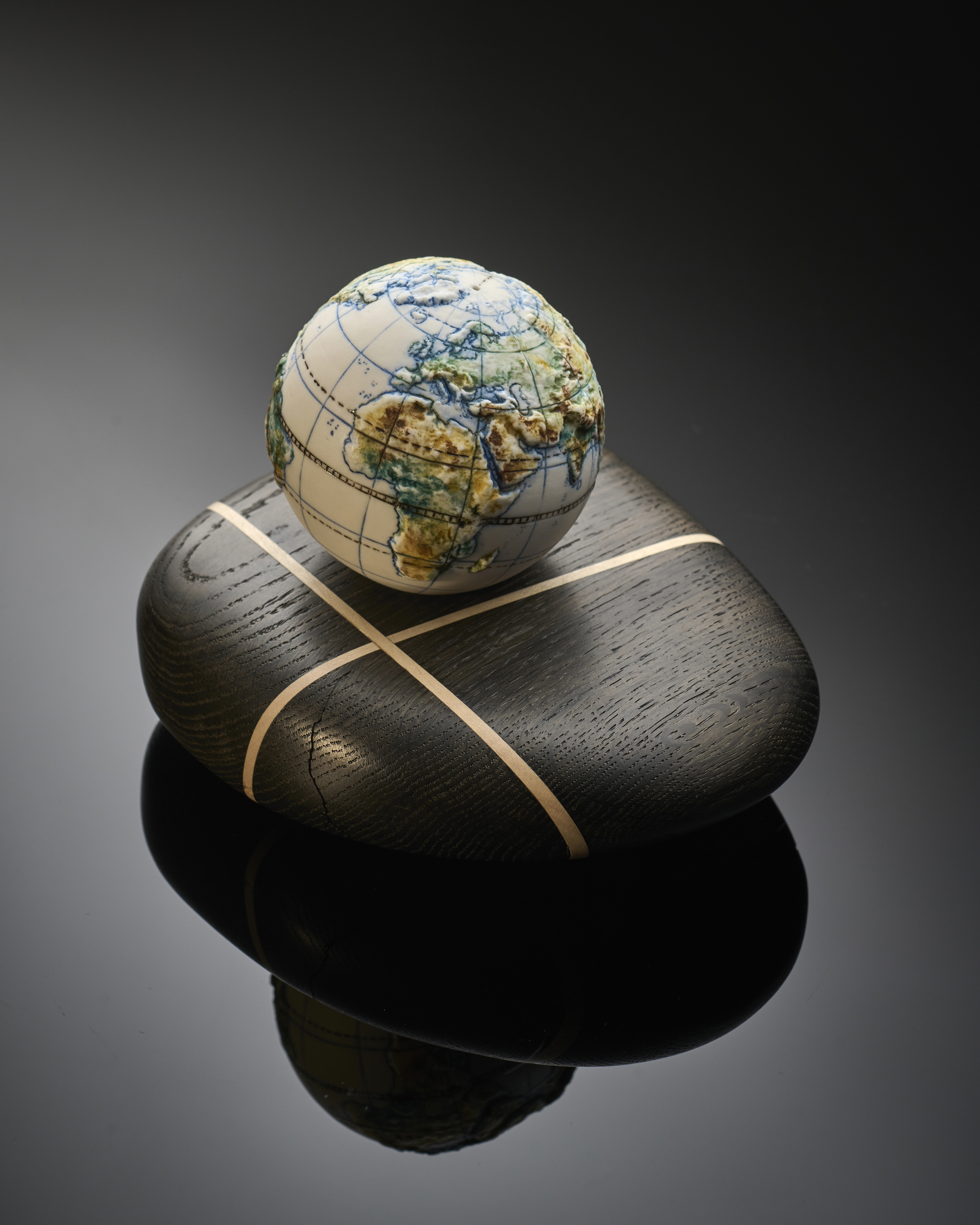 Small globe on dark wooden stand.