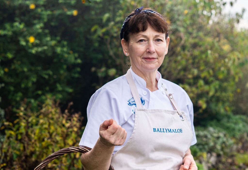 Dervilla O'Flynn, Executive Chef at Ballymaloe House Hotel, holding a basket of vegetables.